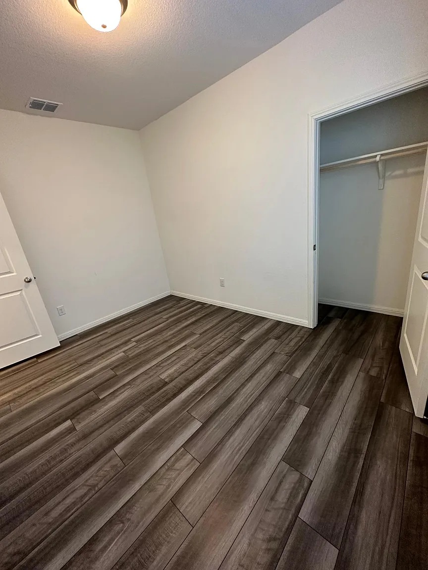114 Aoudad Road Hutto, TX 78634 - Photo 11 of 22 Unfurnished bedroom with dark wood-style floors, a closet, and a textured ceiling