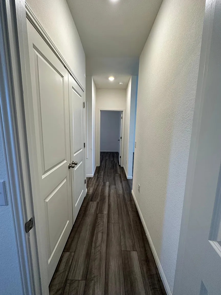 114 Aoudad Road Hutto, TX 78634 - Photo 12 of 22 Hall featuring dark wood finished floors and a textured wall