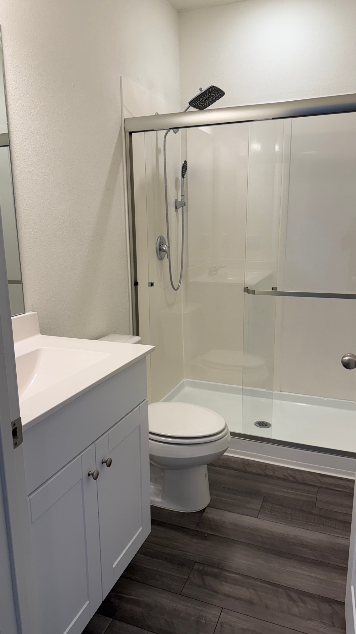 114 Aoudad Road Hutto, TX 78634 - Photo 16 of 22 Full bathroom with vanity, a shower stall, and dark wood finished floors