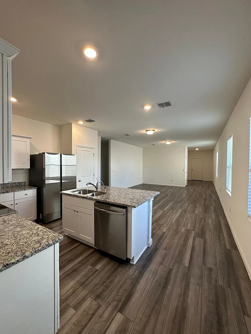 114 Aoudad Road Hutto, TX 78634 - Photo 21 of 22 Kitchen with white cabinets, dark wood-type flooring, stainless steel appliances, dark stone counters, and open floor plan