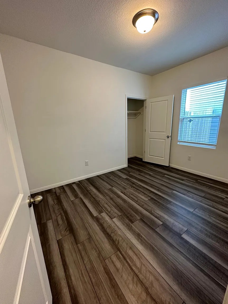 114 Aoudad Road Hutto, TX 78634 - Photo 8 of 22 Unfurnished bedroom featuring a textured ceiling, dark wood finished floors, and a closet