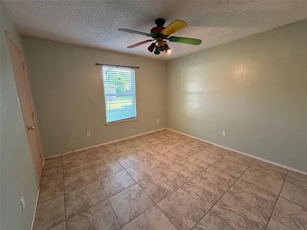 an empty room and chandelier fan