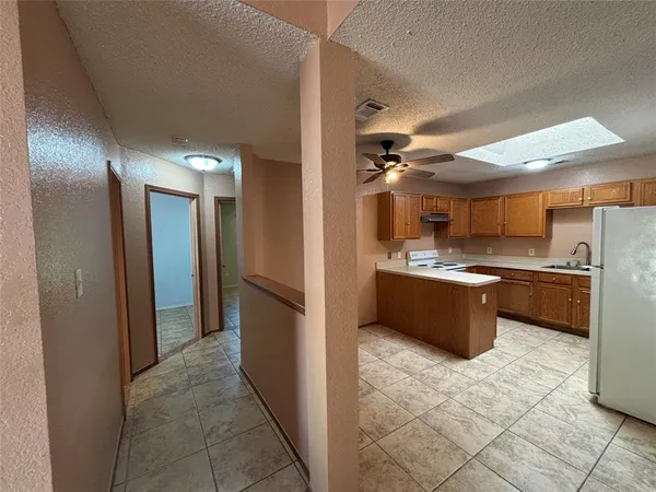 a large kitchen with a window and stainless steel appliances