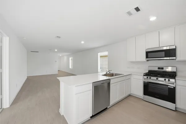 a kitchen with a sink a stove and microwave