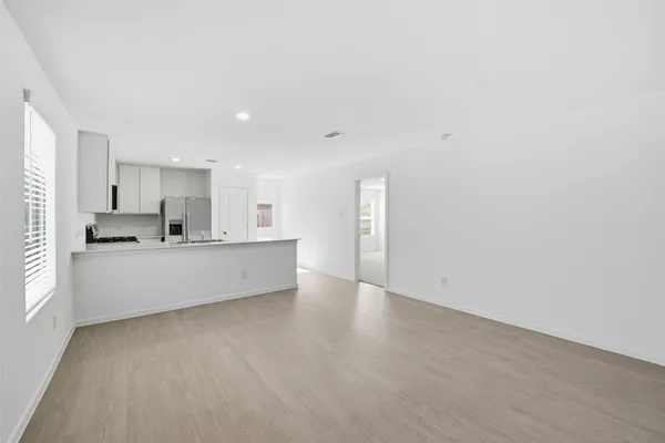 a large kitchen with stainless steel appliances a large counter top a stove and a refrigerator