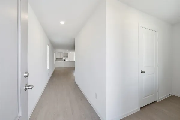 a view of a hallway with wooden floor
