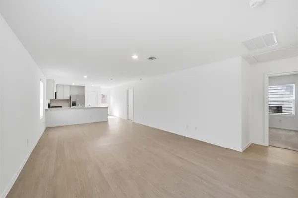 a view of a kitchen with a sink and dishwasher a refrigerator with white cabinets