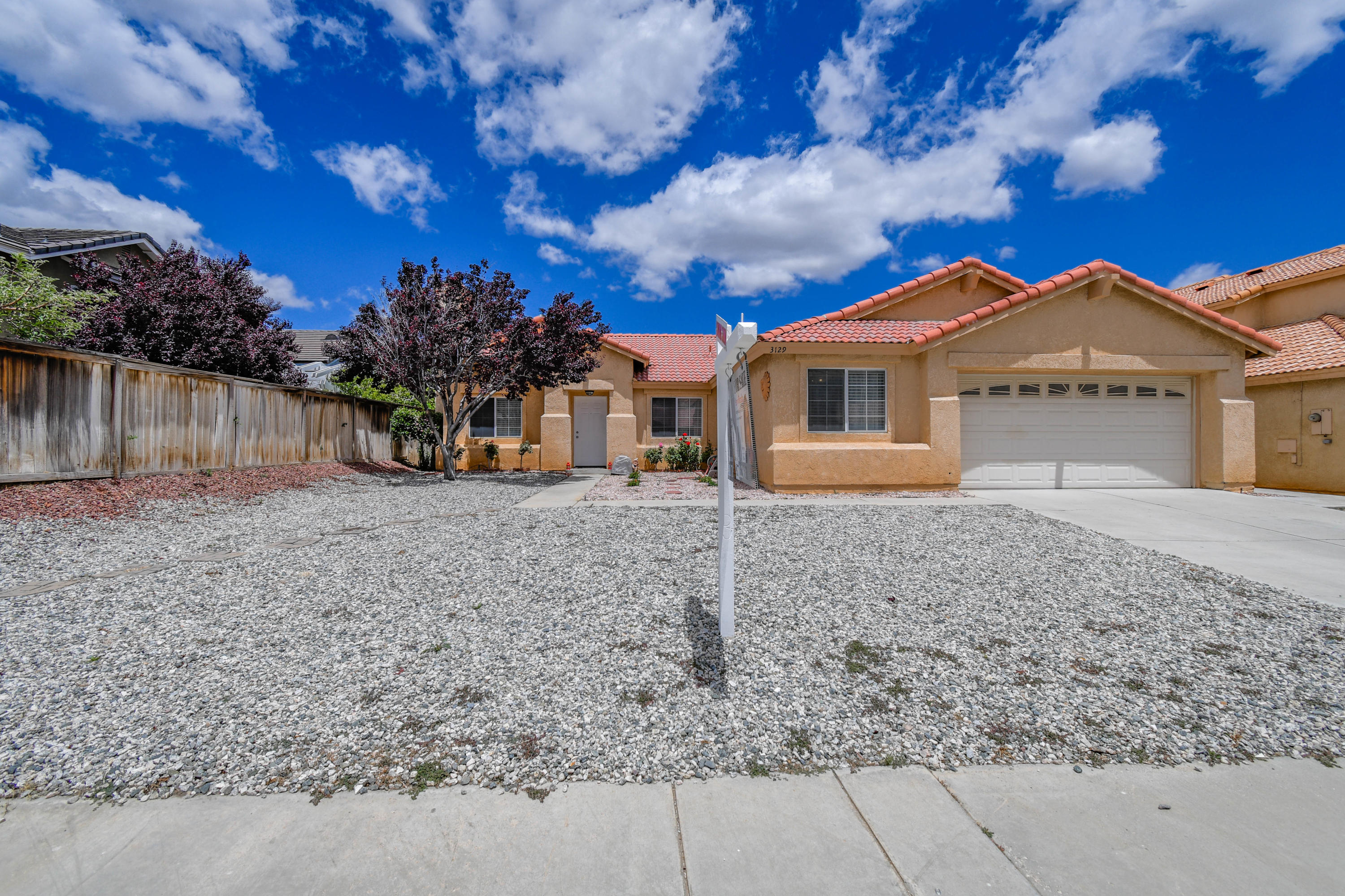 3129 Quarry Road Palmdale, CA 93550 - Photo 1 of 19 a view of a large house with a big yard and large tree