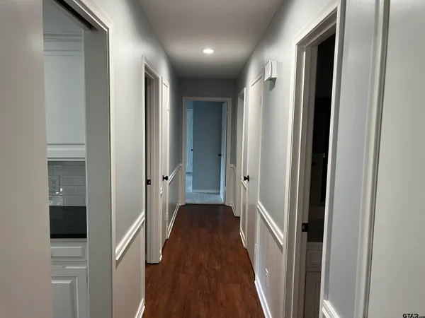 a view of a hallway with wooden floor and staircase