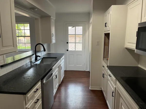 a kitchen with granite countertop a sink and a stove top oven