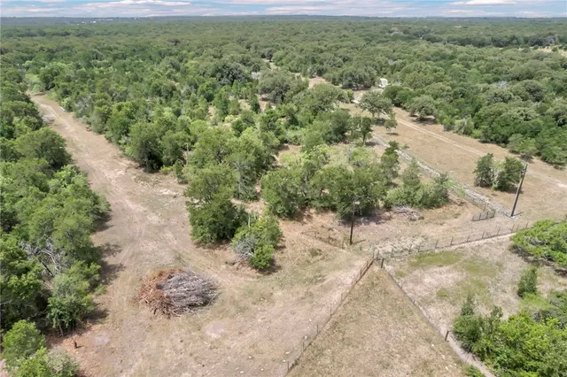 an aerial view of residential house with space and trees all around