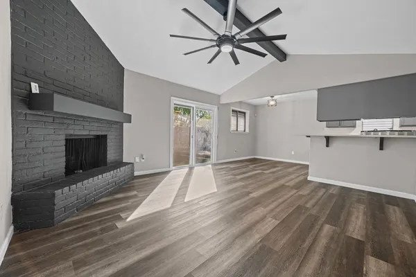 a view of empty room with wooden floor and fireplace