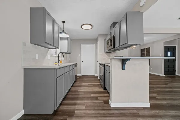 a kitchen with stainless steel appliances a sink and cabinets