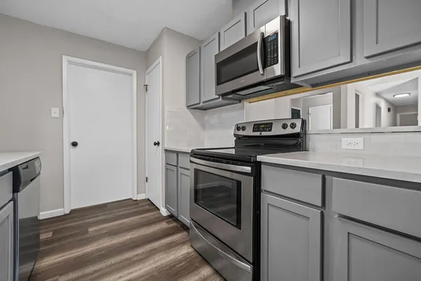 a kitchen with stainless steel appliances granite countertop cabinets and a stove top oven