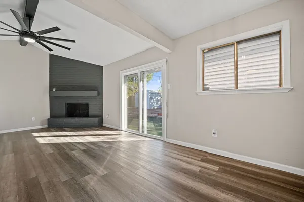 a view of an empty room with a fireplace and a window
