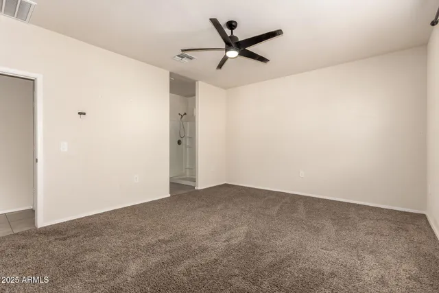 an empty room with closet and a chandelier fan
