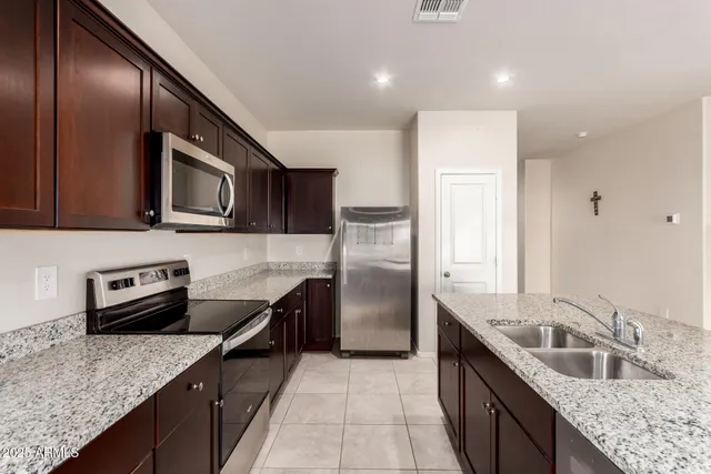 a kitchen with stainless steel appliances granite countertop a sink stove and refrigerator