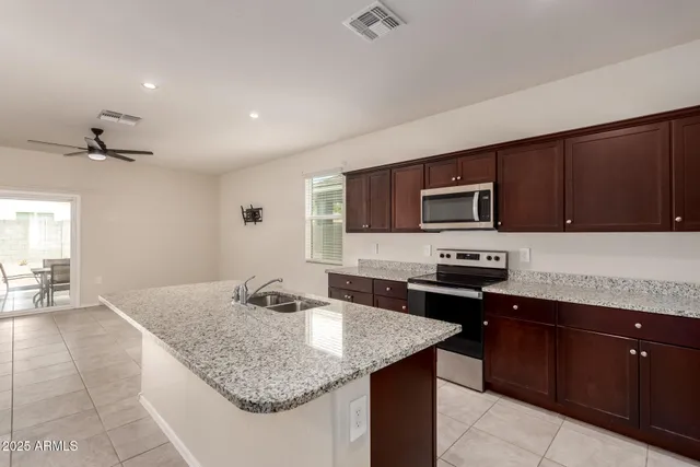 a kitchen with stainless steel appliances granite countertop a sink dishwasher stove and oven