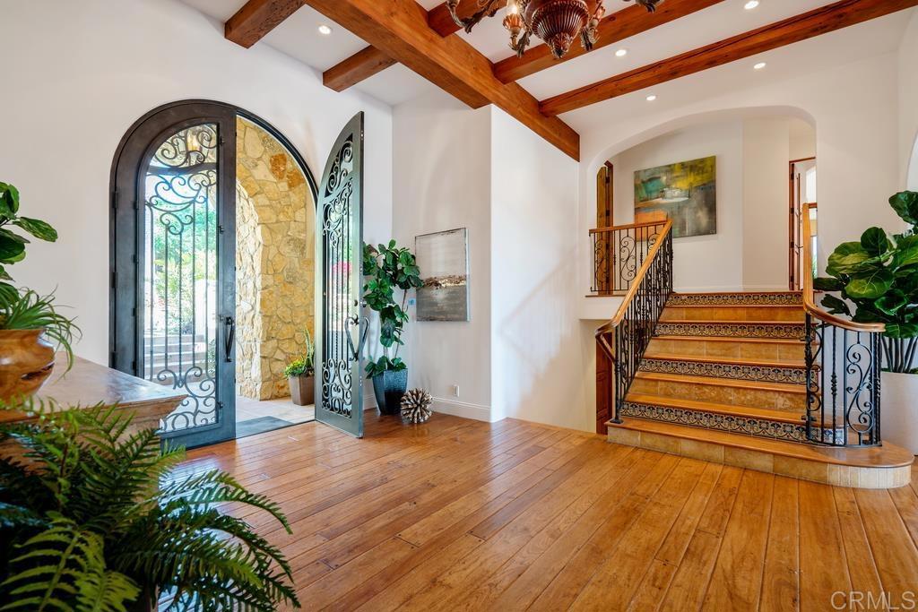 17140 El Mirador Rancho Santa Fe, CA 92067 - Photo 12 of 18 a view of front door with potted plants and wooden floor