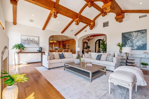 a living room with furniture a fireplace and a chandelier