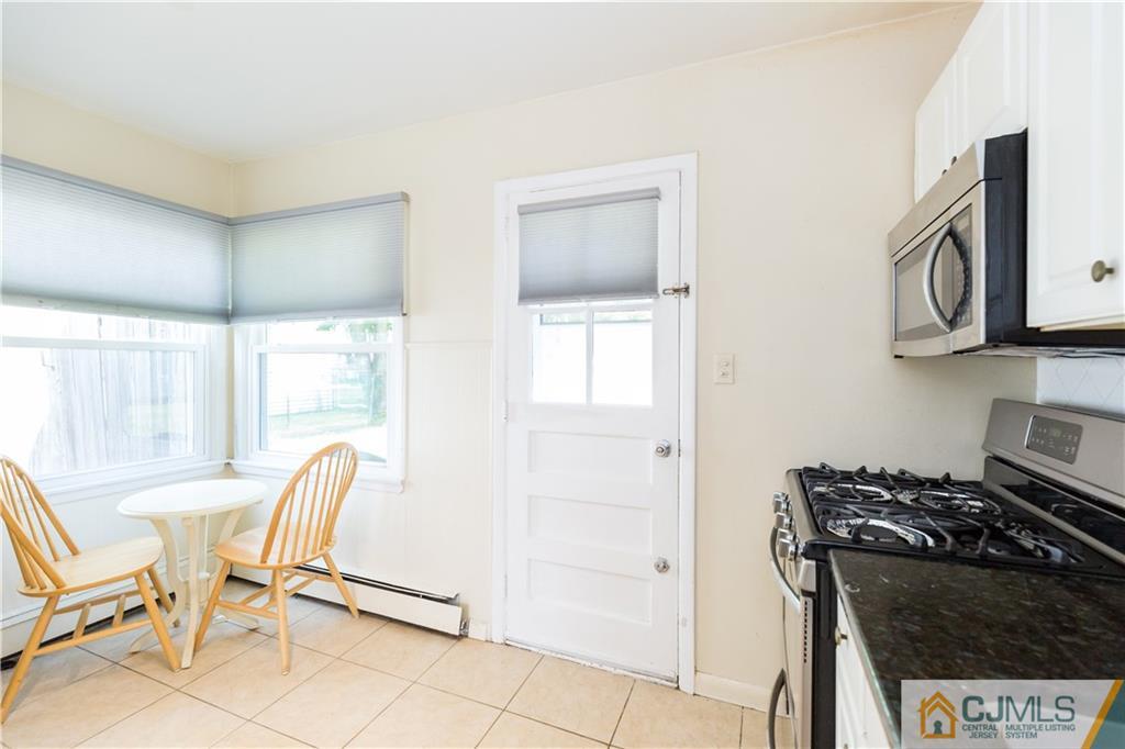 5 Mercury Road Edison, NJ 08817 - Photo 11 of 29 a kitchen with stainless steel appliances a stove a table and chairs in it