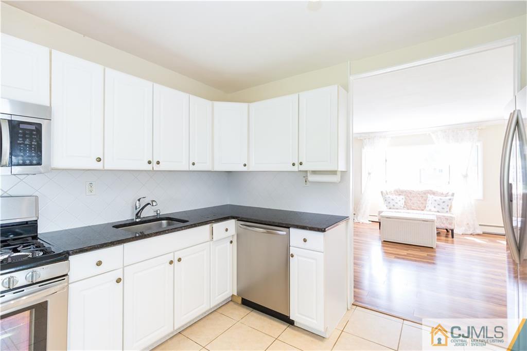 5 Mercury Road Edison, NJ 08817 - Photo 12 of 29 a kitchen with a sink dishwasher and white cabinets with wooden floor