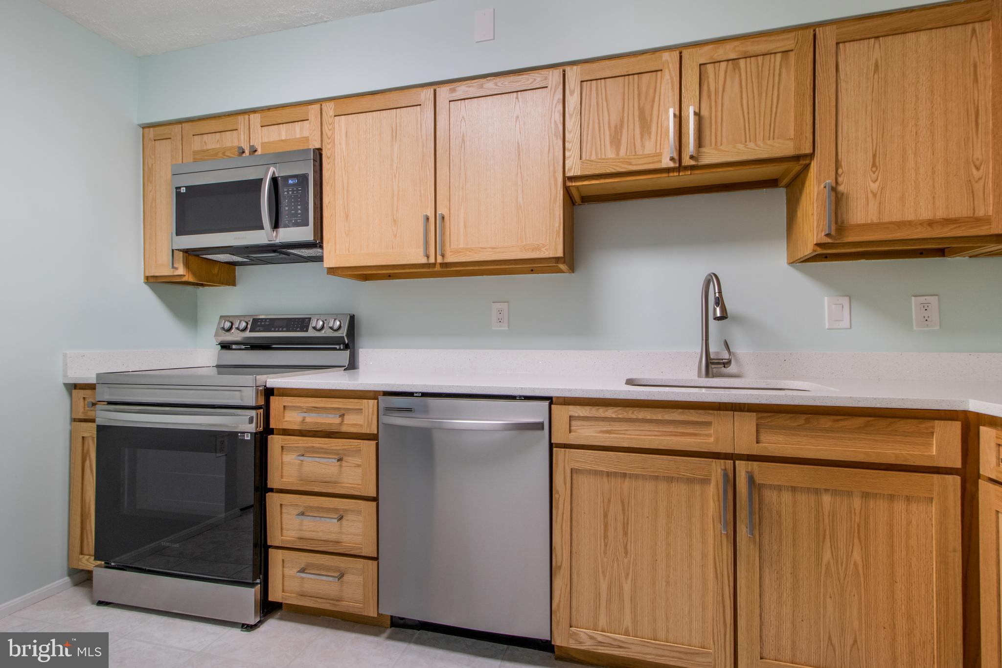 15115 Interlachen Drive, Unit 31020 Silver Spring, MD 20906 - Photo 12 of 48 a kitchen with stainless steel appliances granite countertop a refrigerator and cabinets