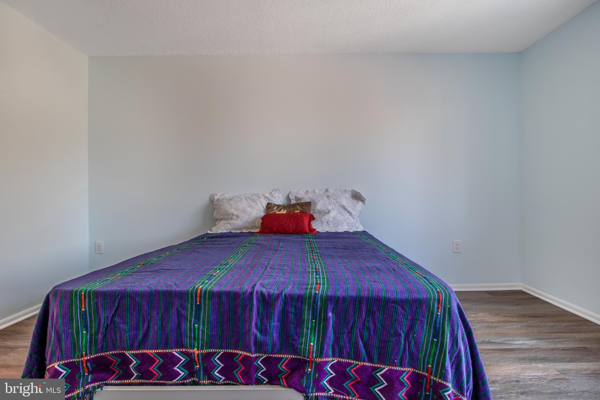 15115 Interlachen Drive, Unit 31020 Silver Spring, MD 20906 - Photo 31 of 48 a bed sitting in a bedroom next to a wooden cabinet