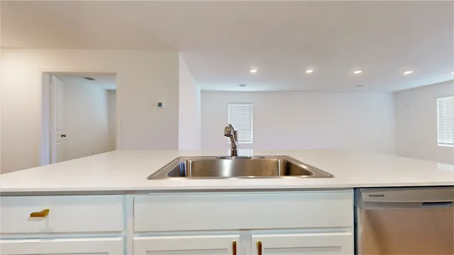 a kitchen with a sink and washing machine with the wooden floor