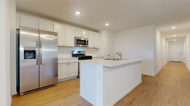 a kitchen with kitchen island a sink stainless steel appliances and cabinets