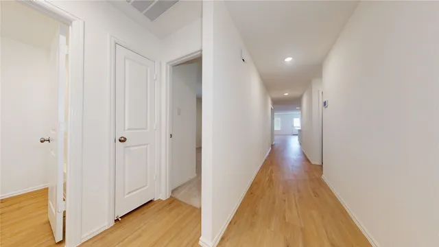 a view of a hallway with wooden floor