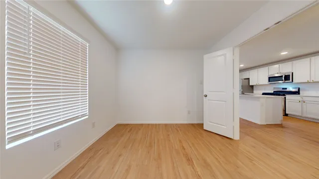 a view of a kitchen with wooden floor and a window
