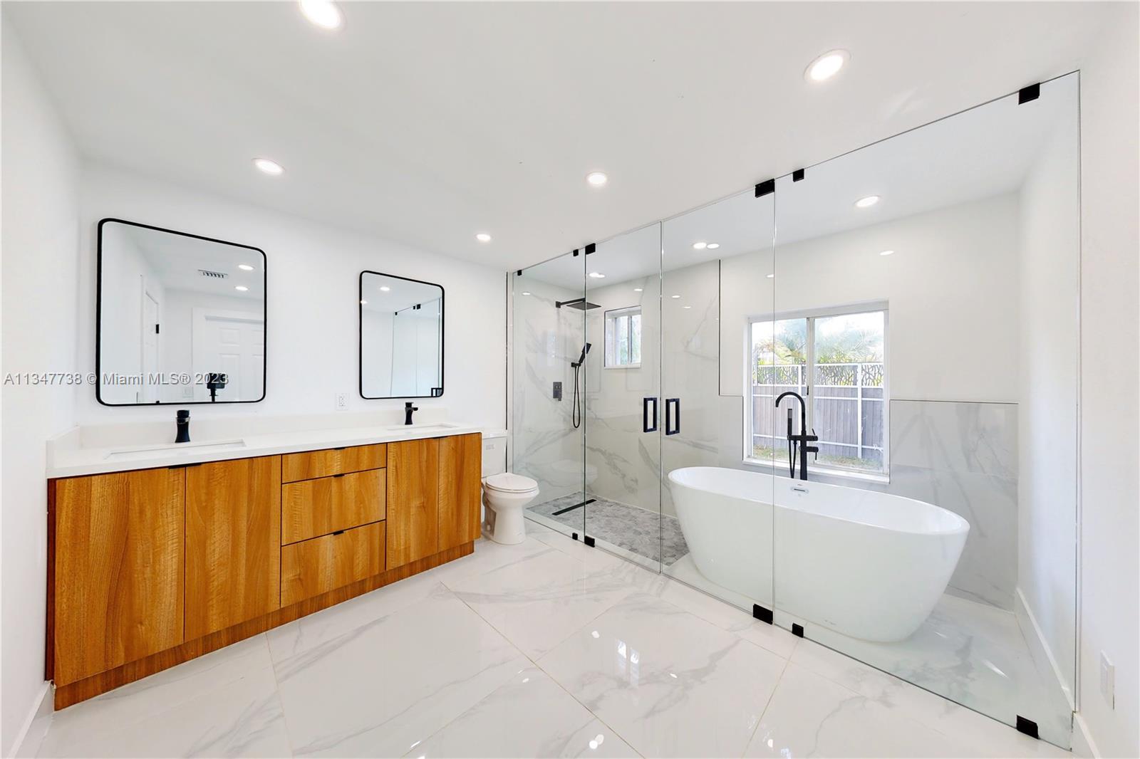 7950 Southwest 22nd Street Miami, FL 33155 - Photo 13 of 36 a spacious bathroom with a double vanity sink mirror and bathtub