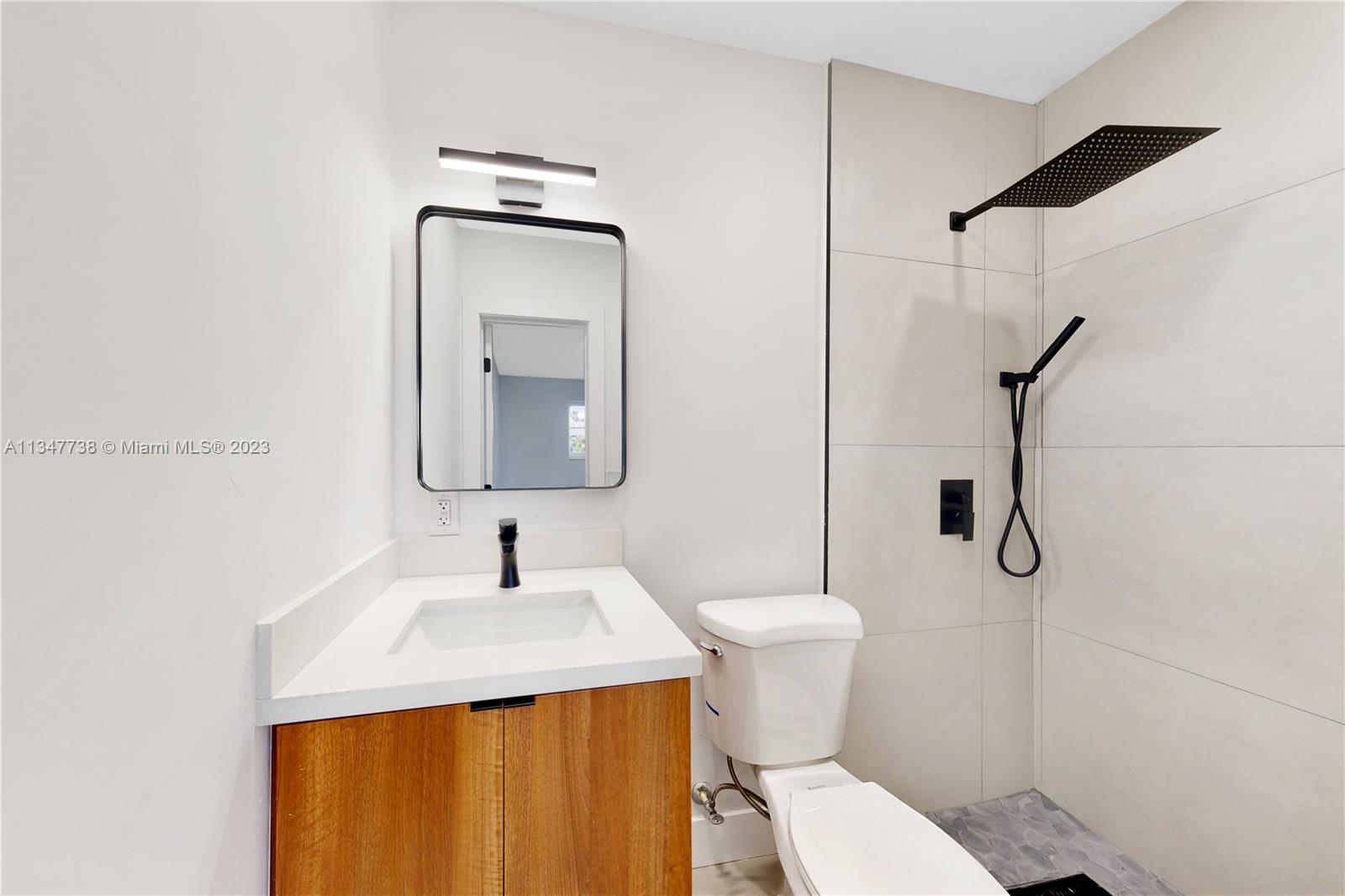 7950 Southwest 22nd Street Miami, FL 33155 - Photo 17 of 36 a bathroom with a toilet sink and mirror