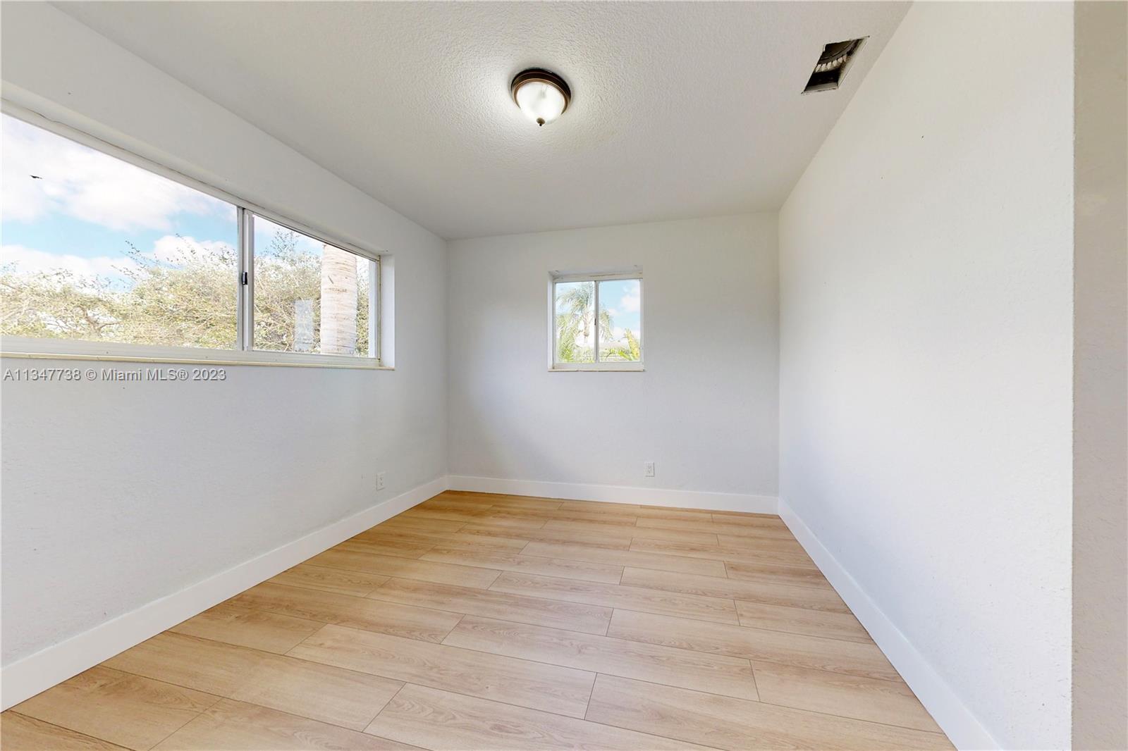 7950 Southwest 22nd Street Miami, FL 33155 - Photo 20 of 36 a view of an empty room with wooden floor and a window