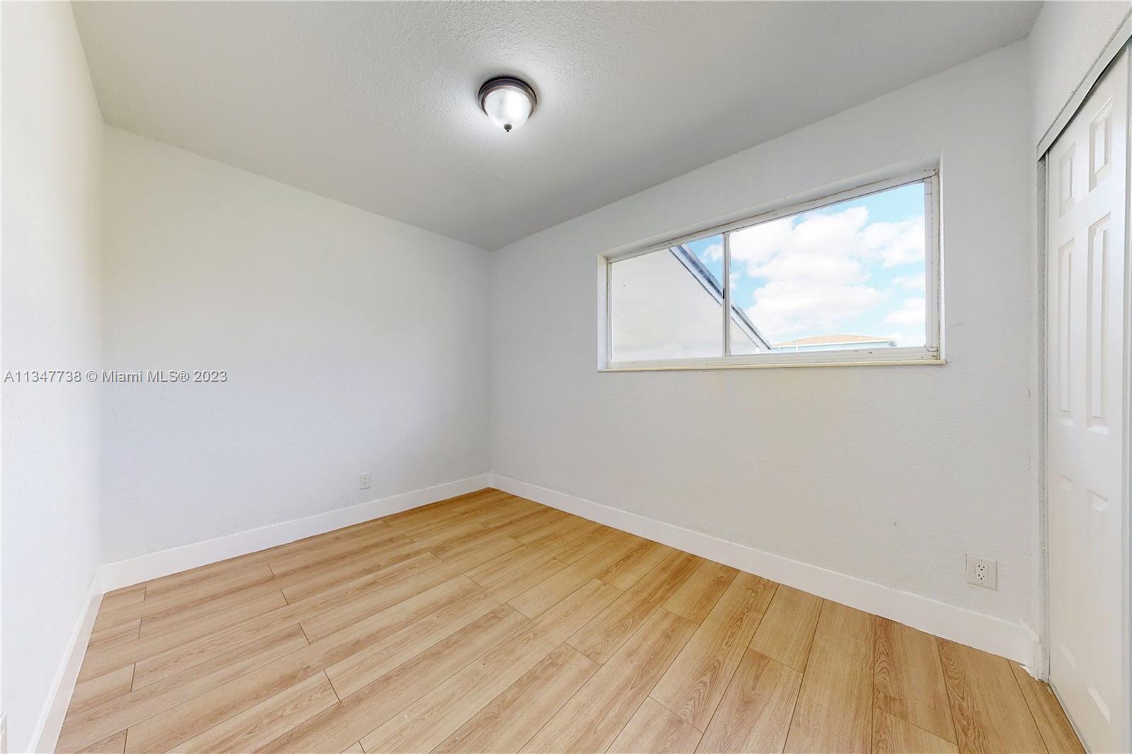 7950 Southwest 22nd Street Miami, FL 33155 - Photo 23 of 36 an empty room with wooden floor and windows