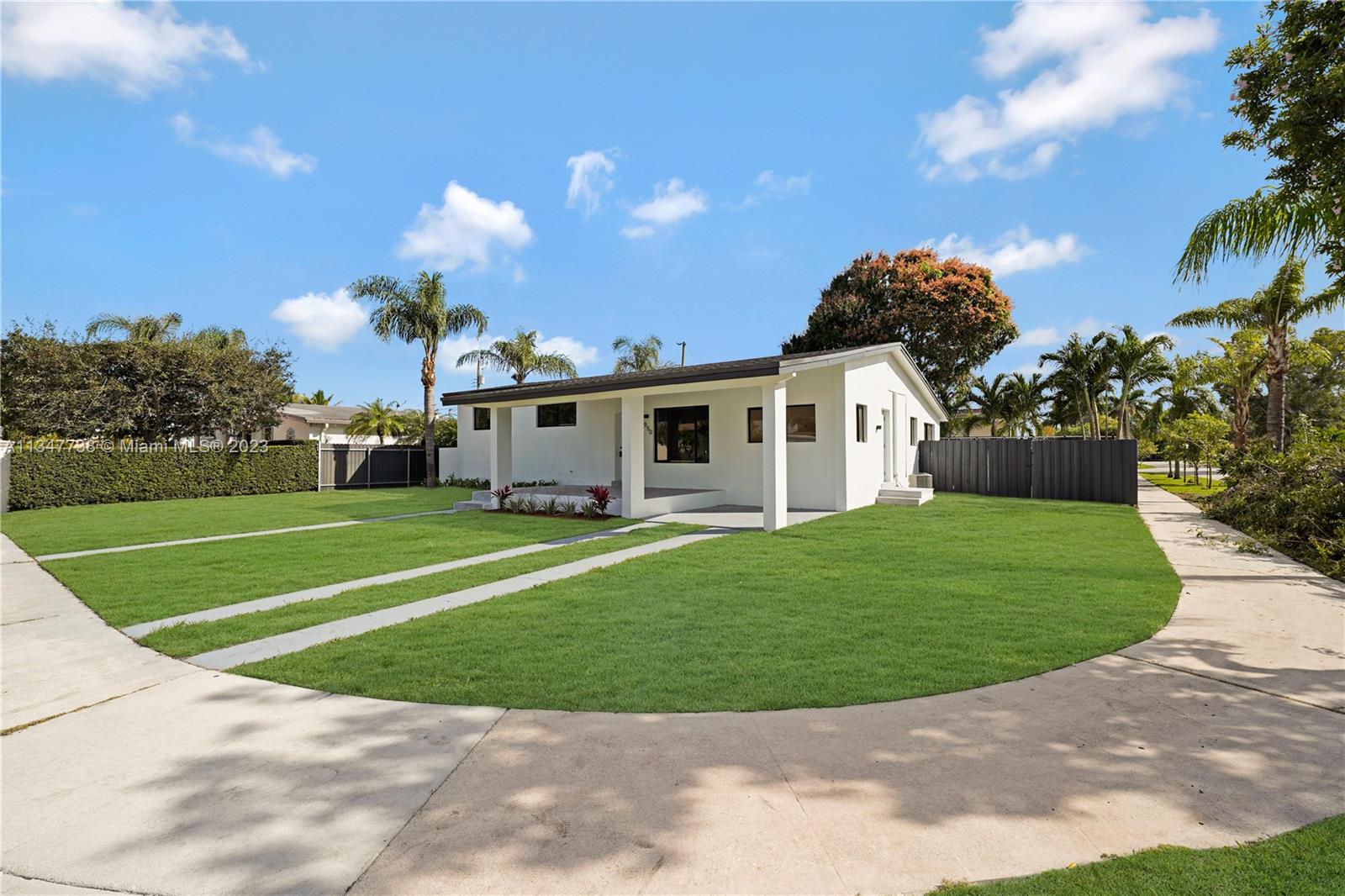 7950 Southwest 22nd Street Miami, FL 33155 - Photo 35 of 36 a view of a white house with a big yard and potted plants