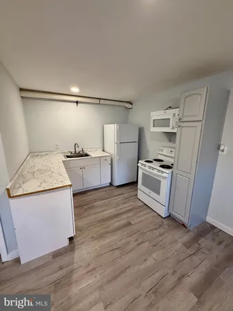 a kitchen with granite countertop a refrigerator and a stove top oven