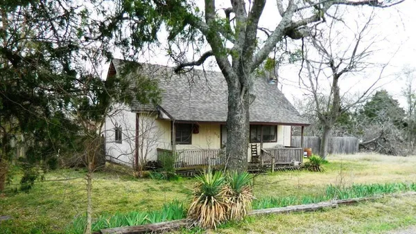 a backyard of a house with table and chairs