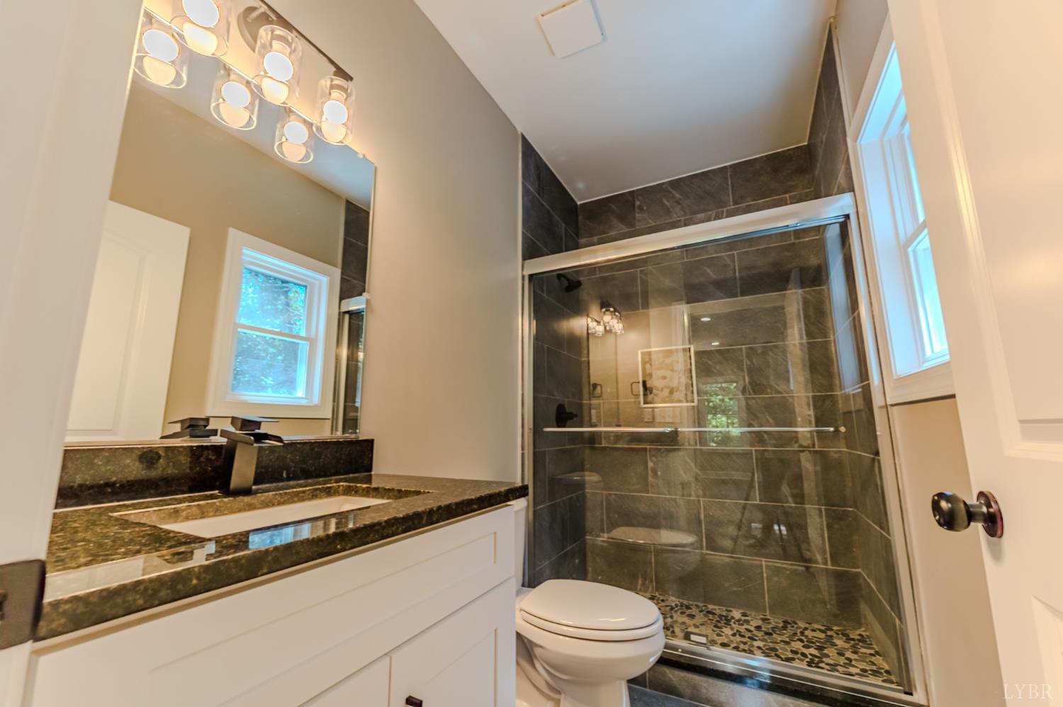 109 Tosh Lane Goodview, VA 24095 - Photo 18 of 32 a bathroom with a granite countertop sink toilet and shower