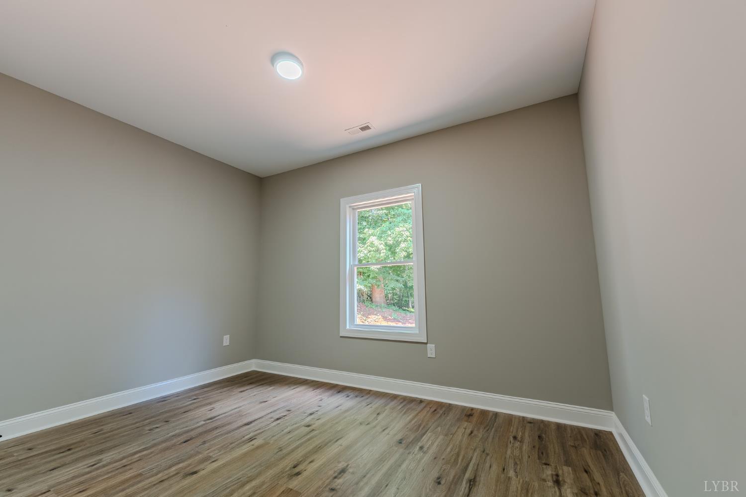 109 Tosh Lane Goodview, VA 24095 - Photo 22 of 32 a view of an empty room with wooden floor and a window
