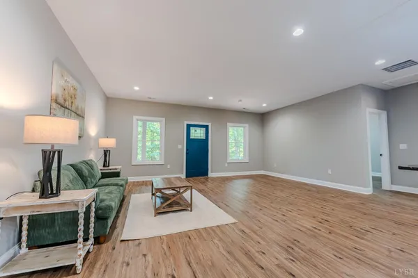 a kitchen with stainless steel appliances granite countertop a refrigerator a sink dishwasher a stove and white countertops with wooden floor