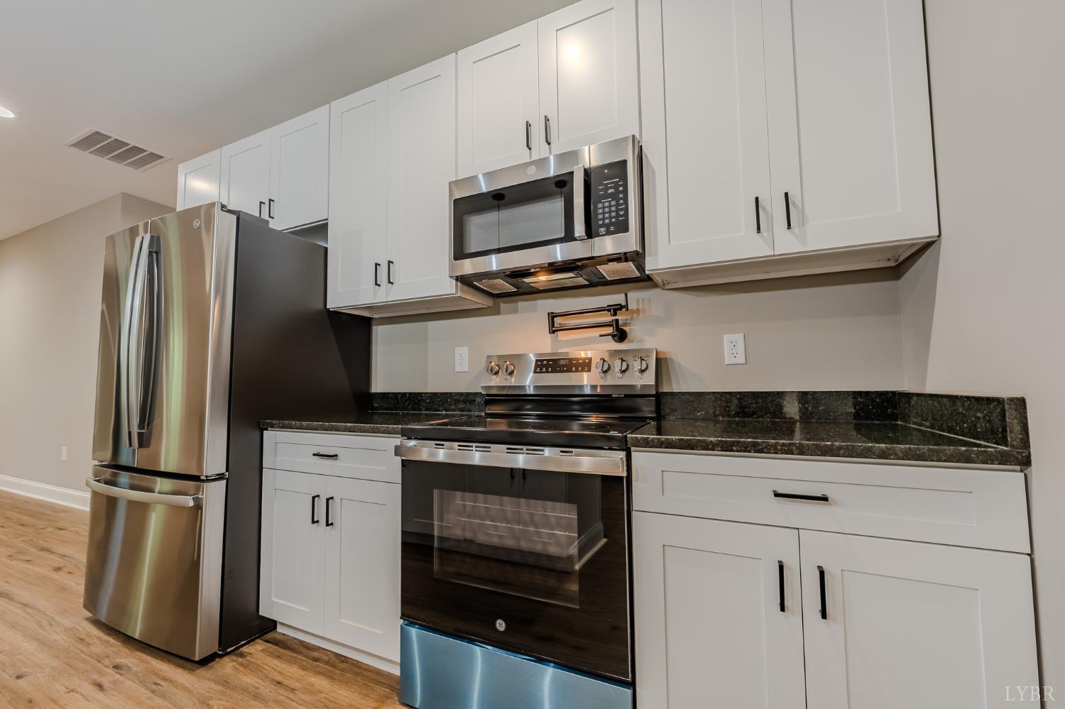 109 Tosh Lane Goodview, VA 24095 - Photo 28 of 32 a kitchen with granite countertop a refrigerator stove and microwave