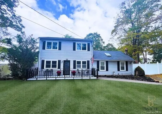 a front view of a house with a garden and trees