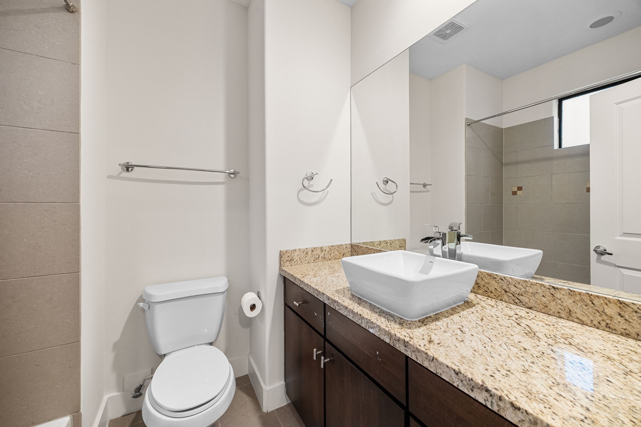 2005 Hickory Street Houston, TX 77007 - Photo 21 of 27 a bathroom with a granite countertop sink a mirror and a toilet