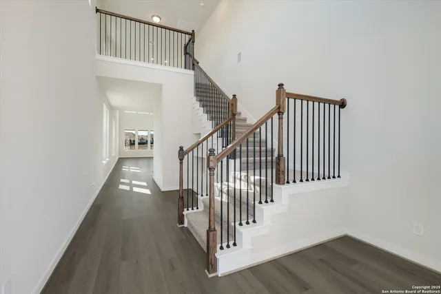a view of staircase with railing and white walls