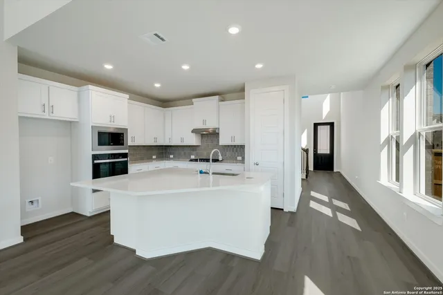 a view of kitchen with stainless steel appliances refrigerator oven stove microwave and cabinets