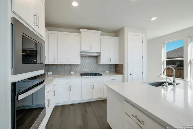 a kitchen with a sink stove and cabinets