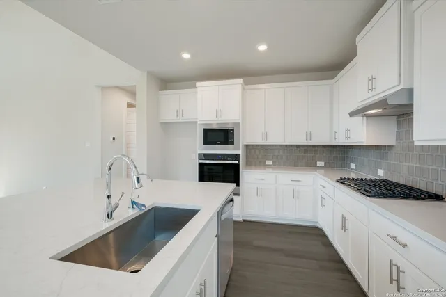 a kitchen with white cabinets and white appliances