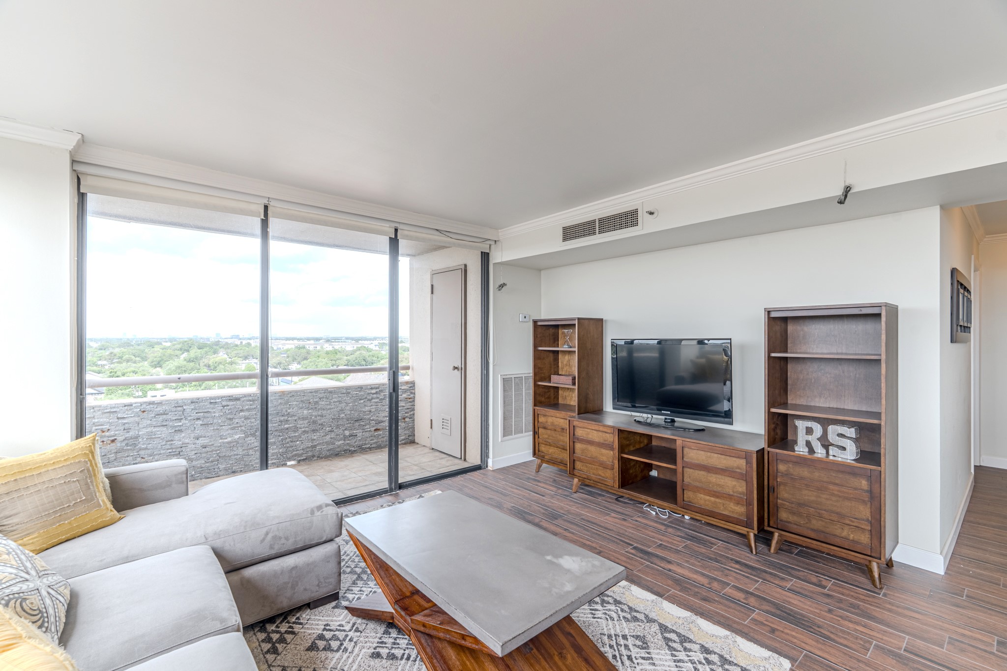 3525 Sage Road, Unit 1016 Houston, TX 77056 - Photo 24 of 42 a living room with furniture a flat screen tv and a floor to ceiling window